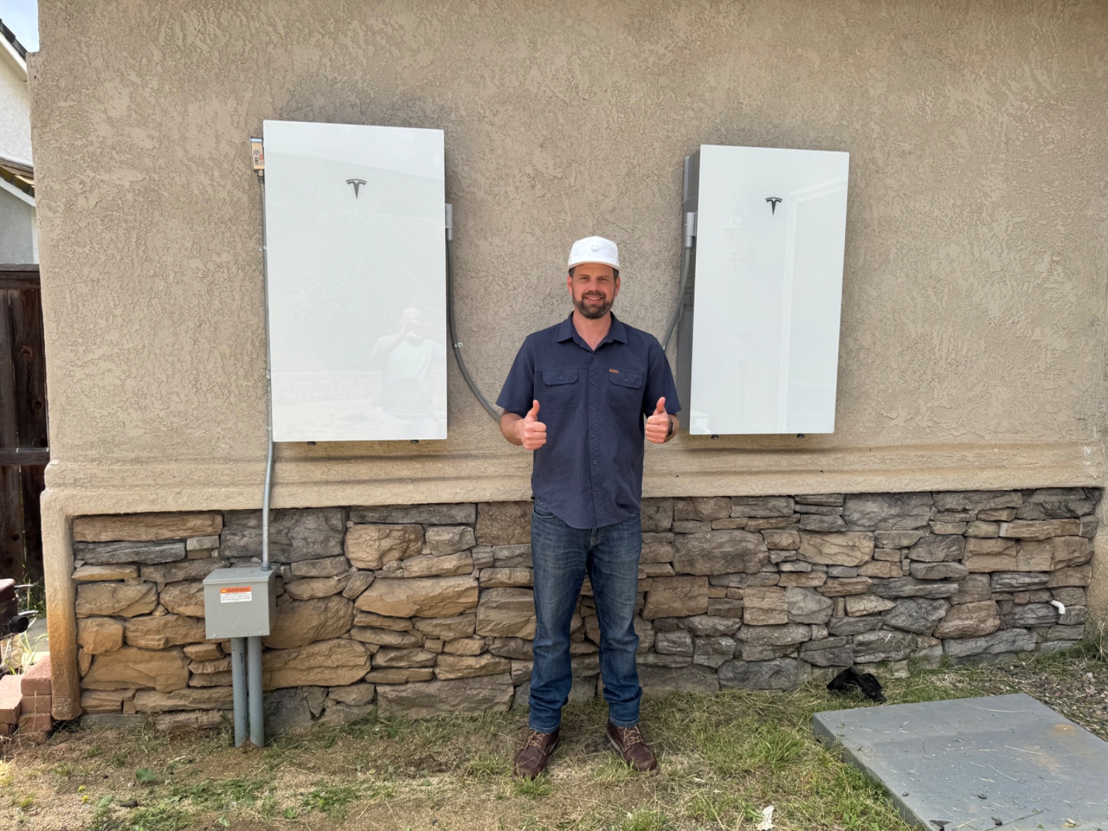 Devin standing between two installed Tesla Powerwalls.